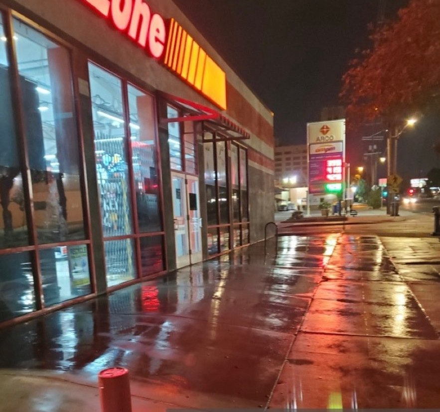AutoZone storefront at night with freshly washed sidewalk